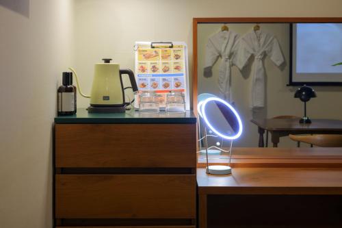 a dresser with a mirror and a light on it at Aank Hotel Jeonju in Jeonju