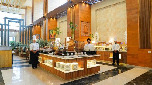 un grupo de chefs parados en una cocina en The Meriton, en Jāmb