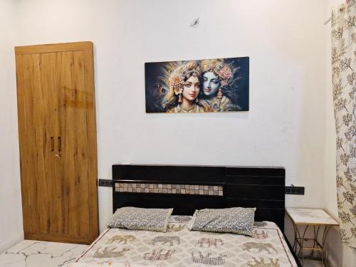 a bedroom with a bed with a picture on the wall at Nirmal sadan Homestay in Barsāna