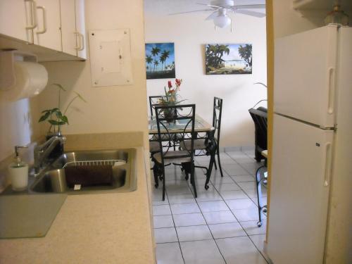 a kitchen with a sink and a table with chairs at Ocean Front Apartment in Luquillo