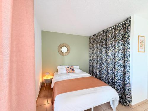 two beds in a small room with a curtain at M36 Joli studio proche de la gare in Annemasse