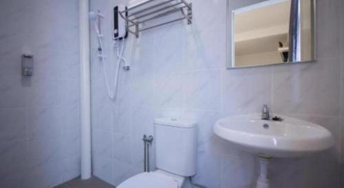 a white bathroom with a toilet and a sink at D Nice Hotel in George Town