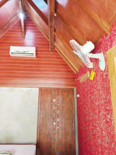 a room with a ceiling fan and a door at Kondo Villa in Labuhan Pandan