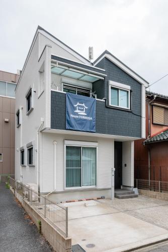 a house with a blue banner on the side of it at House FORMOSA熱田 in Nagoya