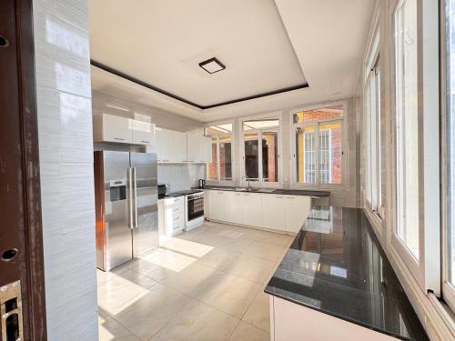 a large kitchen with white appliances and windows at Family Corner Suite by Iwacu Stays in Kigali