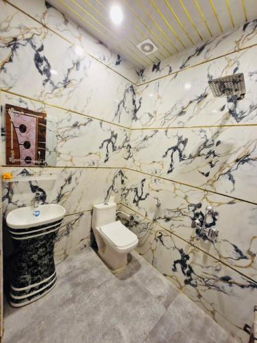 a bathroom with a black and white marble wall at Nirmal sadan Homestay in Barsāna