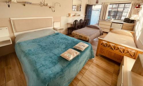 a room with two beds and a kitchen with at Ezeiza 3 departamento privado a 15 minutos del aeropuerto hasta 7 personas OPCIONAL TRANFER DESDE Y HACIA EL AEROPUERTO DE EZEIZA LAS 24 HORAS pet friendly conexion con Aeroparque in Ezeiza
