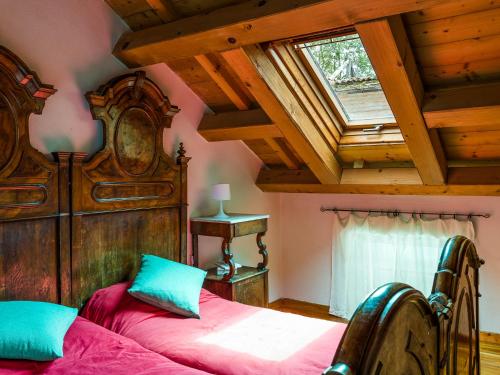 sypialnia z drewnianym łóżkiem i oknem w obiekcie Agriturismo Casa de Bertoldi w mieście Belluno