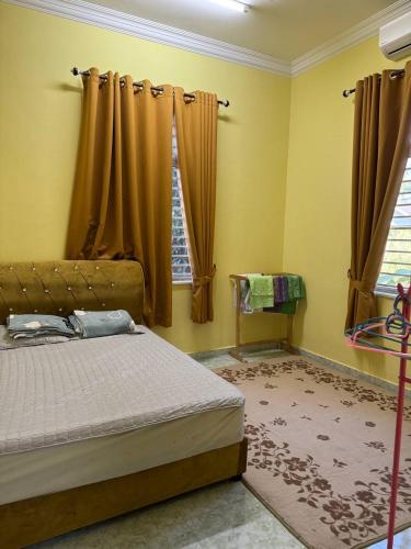 a bedroom with a bed and a window with curtains at HB Warisan Homestay in Kota Bharu