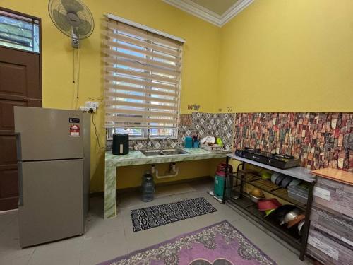 a kitchen with a sink and a refrigerator and a window at HB Warisan Homestay in Kota Bharu