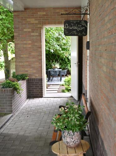a patio with a table and a potted plant at De Weideblom in Schermerhorn