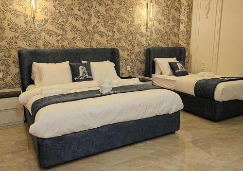 two beds in a hotel room with two bedsvisor at Skyline Hotel in Sargodha