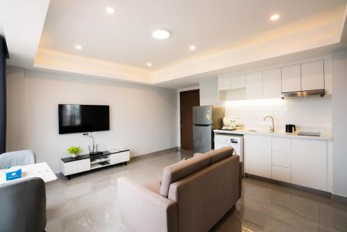 a living room with a couch and a kitchen at Parc21 Luxury Boutique Hotel in Phnom Penh