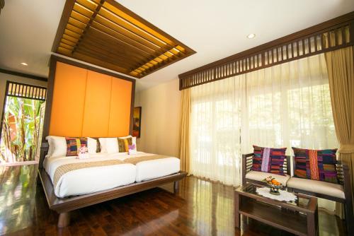 a bedroom with a large bed and a window at Sibsan Resort & Spa Maetaeng Chiang Mai in Mae Taeng