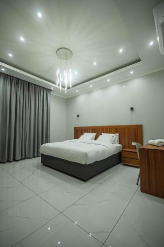 ein Schlafzimmer mit einem großen Bett und einem Schreibtisch in der Unterkunft Ultra Aparthotel in Tete