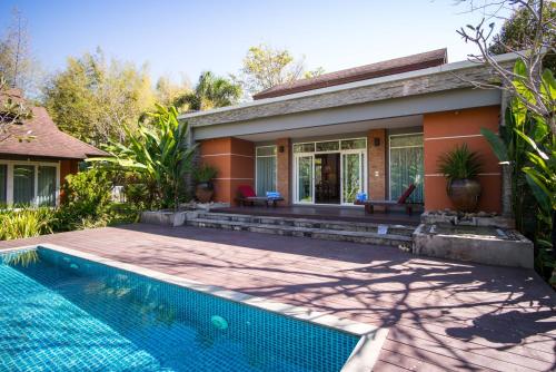 a house with a swimming pool in front of a house at Sibsan Resort & Spa Maetaeng Chiang Mai in Mae Taeng