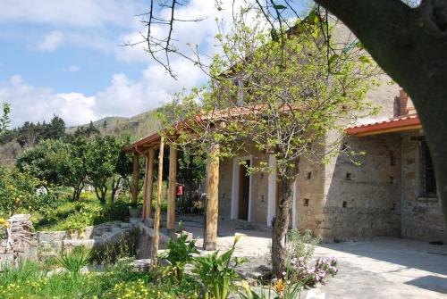 ein Steinhaus mit einem Baum davor in der Unterkunft Al Melograno B&B in Belmonte Calabro
