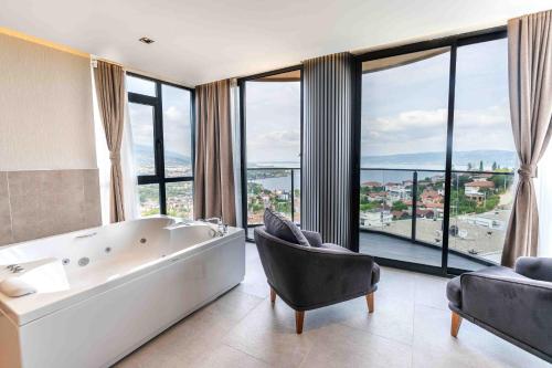 ein großes Badezimmer mit Badewanne, Stuhl und Fenstern in der Unterkunft Sapanora Hotel in Sapanca