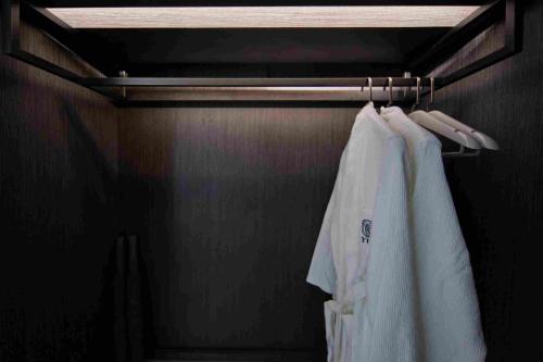 a closet with a white shirt hanging on a rack at 西双版纳熙源国际酒店 in Jinghong