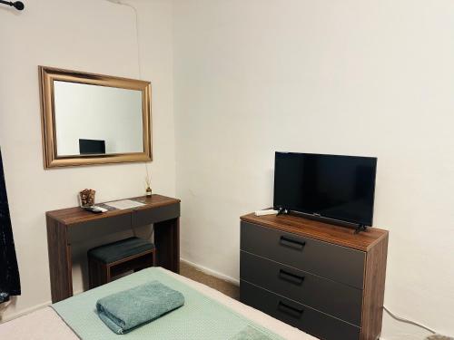 a bedroom with a tv on a dresser and a mirror at Sea Breeze Retreat - Comfort Apartments in the Heart of Sliema in Sliema