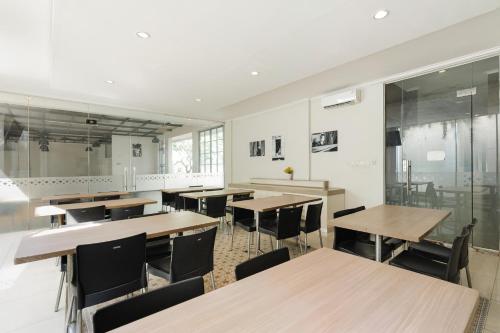 an empty classroom with wooden tables and chairs at Sans Vibes Firdaus Mansion Kemang in Jakarta