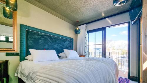 a bedroom with a large bed with a large window at Batavia Boutique Hotel in Stellenbosch