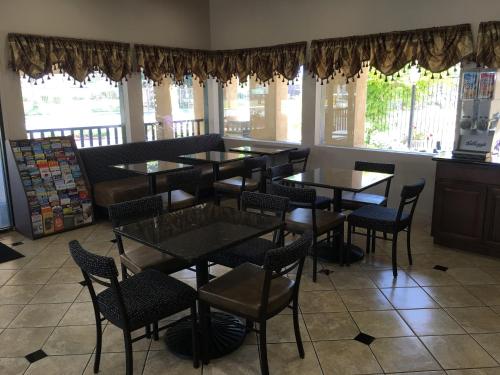 a dining room with tables and chairs and windows at Super 8 by Wyndham Salinas in Salinas
