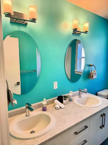 a bathroom with two sinks and two mirrors at Your Halifax Getaway, Relax and Explore in Halifax
