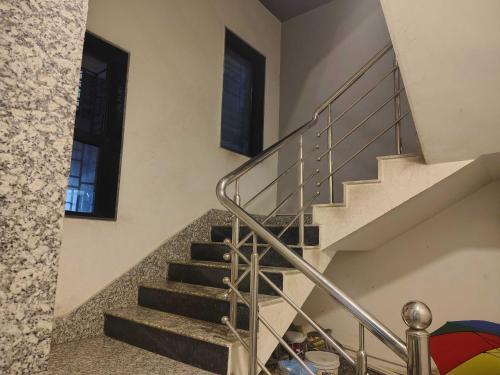 a staircase in a home with a metal railing at Townhouse Madhyamgram Chowmatha Bus Terminal Kolkata Formerly Star Guest House in Dohāri