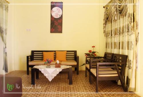 a living room with two chairs and a table at The Norsyah Villa selayar in Pareangang