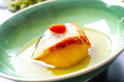 a piece of cake with a cherry on top in a green bowl at Niseko Hot Spring Ikoino Yuyado Iroha in Niseko