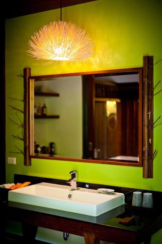 a bathroom with a sink and a large mirror at Sibsan Resort & Spa Maetaeng Chiang Mai in Mae Taeng