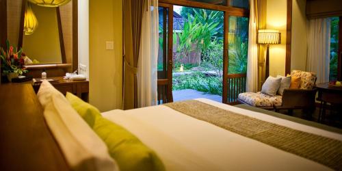 a bedroom with a bed and a door to a garden at Sibsan Resort & Spa Maetaeng Chiang Mai in Mae Taeng