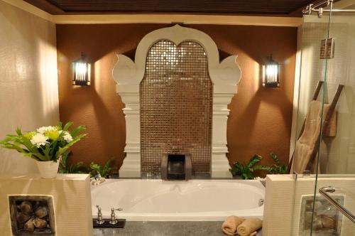 a bathroom with a bath tub with a brick wall at Sibsan Resort & Spa Maetaeng Chiang Mai in Mae Taeng