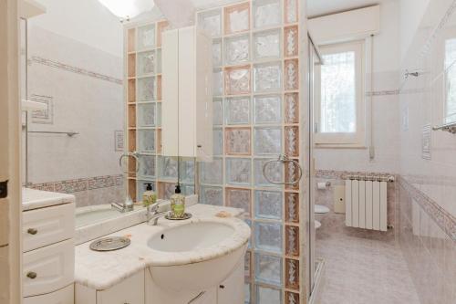 a bathroom with a sink and a glass wall at Ardesia Vacanze in Valderice