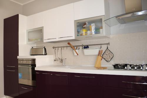 a kitchen with white cabinets and a sink at Villetta Airone in Birgi Vecchi