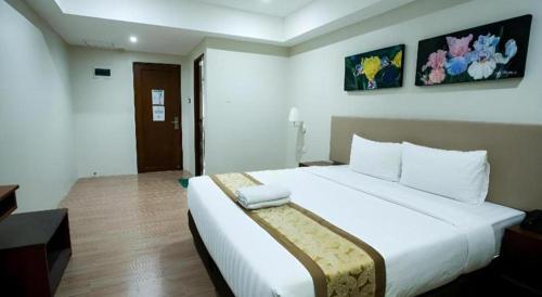 a bedroom with a large white bed in a room at Hotel Fleur de Liz in Panglao