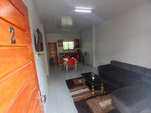 a living room with a black couch and a table at Maitidi Place in Paramaribo