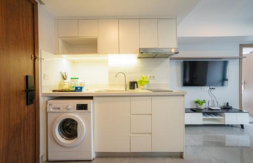 a white kitchen with a washing machine in it at Parc21 Luxury Boutique Hotel in Phnom Penh