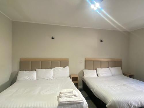 two beds sitting next to each other in a room at Prime Hotel in Northwich