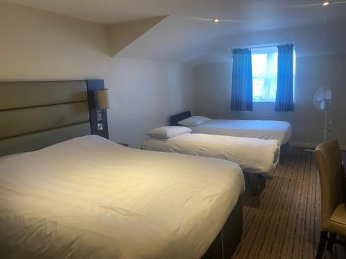 a hotel room with two beds and a window at Prime Hotel in Northwich