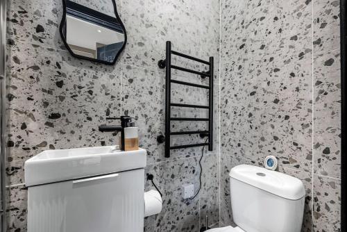 a bathroom with a white toilet and a mirror at Beautifully Designed Studio with Communal Full Kitchen - Full Access in London