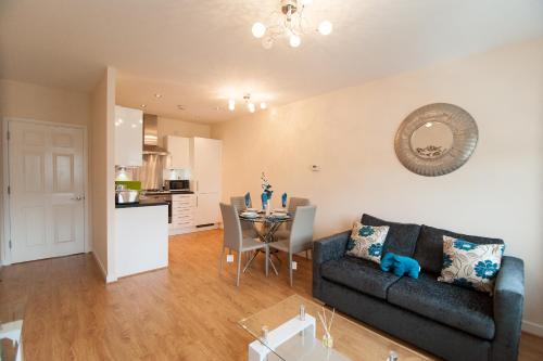 a living room with a couch and a table at Station Suites in Watford