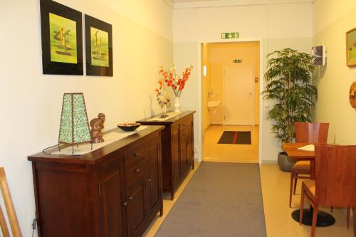 a living room with a wooden cabinet and a hallway at Stationshusets Hotell och Café in Köping