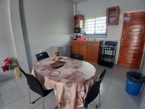 a kitchen with a table and chairs in a room at Maitidi Place in Paramaribo