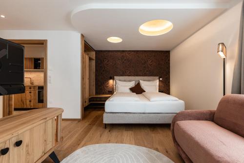 a bedroom with a bed and a tv and a couch at Residence Panorama Pfelders in Pfelders
