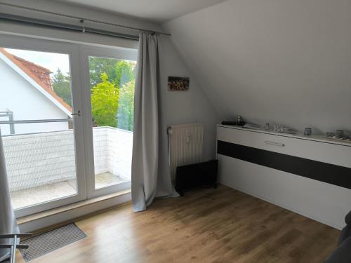 a room with a large window and a wooden floor at Ostseewohnung Weiße Wiek in Hohenkirchen