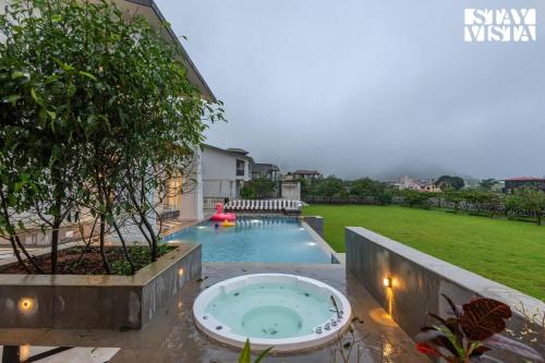 an image of a swimming pool in the backyard of a house at StayVista at Solace Land with Bonfire, Jacuzzi in Lonavala
