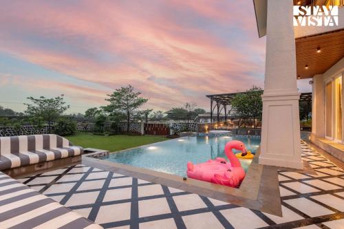 a swimming pool with a pink swan in the middle at StayVista at Solace Land with Bonfire, Jacuzzi in Lonavala