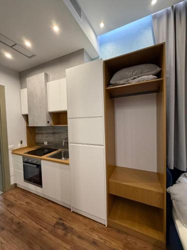 a small kitchen with white cabinets and a sink at Blue Lagoon Stay 